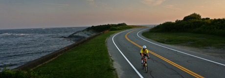 Road cycling, 2010 bike tour - two bicylists silhouetted against the ocean